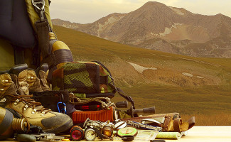 Walking boots and camping gear in front of a Lake District hill